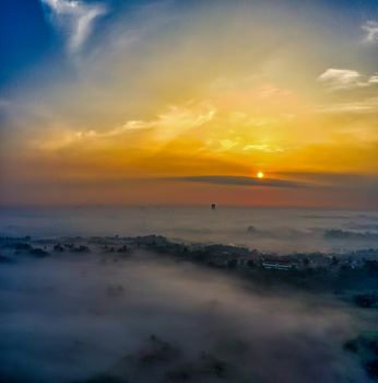 A stunning aerial view of dawn breaking over fog-covered Banten, Indonesia.