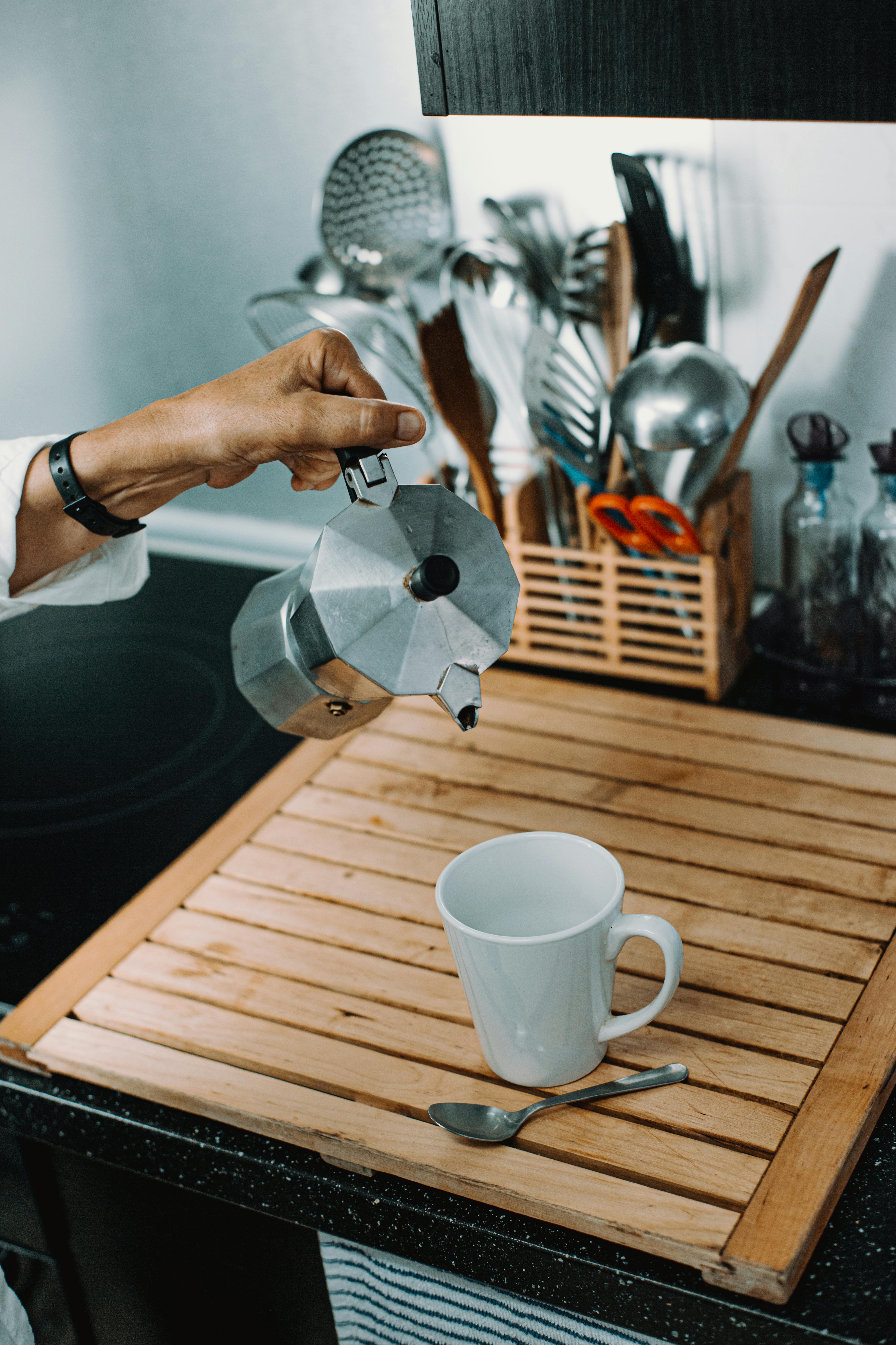 Crop person pouring coffee in cup