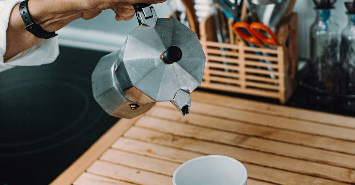 Crop person pouring coffee in cup