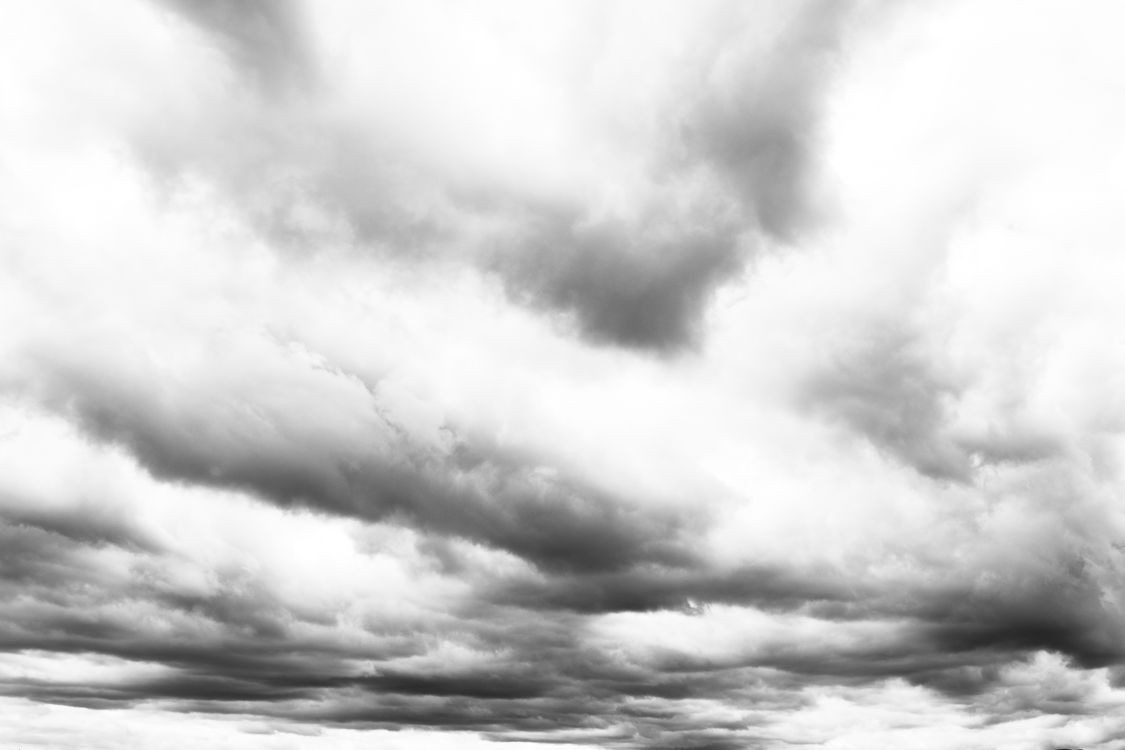 Free Black and white massive cumulus clouds floating on dark sky on gloomy day Stock Photo