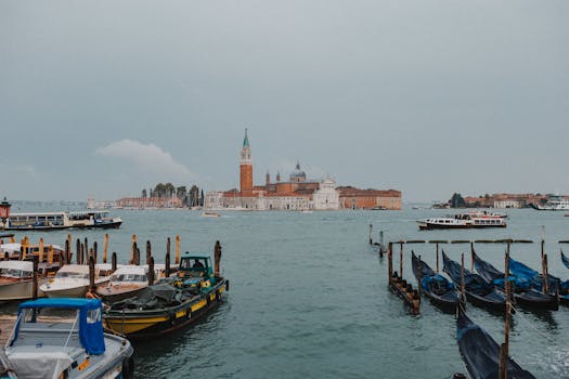 Tranquil scene of Venice's San Giorgio Maggiore with docked boats on a cloudy day.