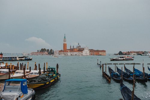 Free Tranquil scene of Venice's San Giorgio Maggiore with docked boats on a cloudy day. Stock Photo