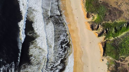 Free Stunning aerial shot of Half Moon Bay beach with waves and cliffs. Stock Photo