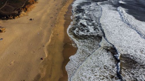 Free High-angle aerial shot showcasing the expansive beach and dynamic waves at Half Moon Bay, California. Stock Photo