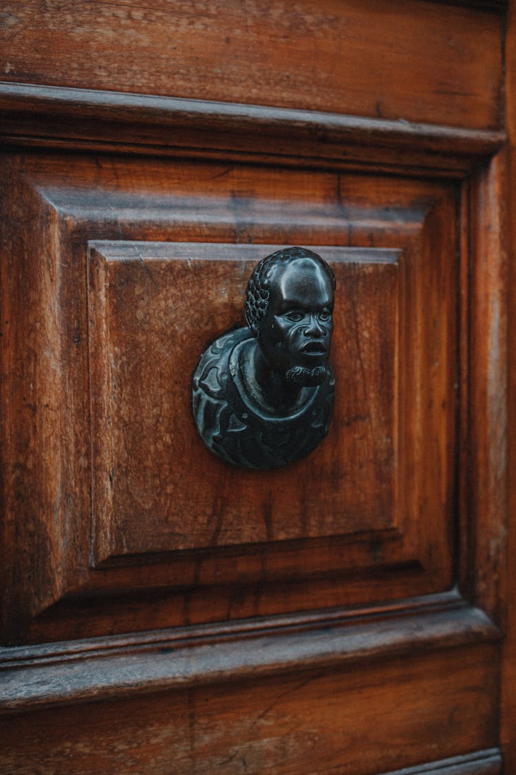 Black Human Face Doorknob On Wooden Door