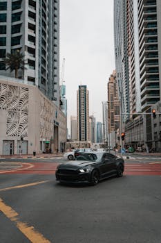 在繁华都市的十字路口，高耸的摩天大楼间，一辆时尚的黑色汽车被捕捉到