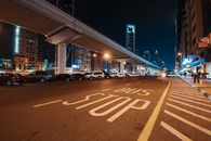 充满活力的夜间城市场景，以高大的发光摩天大楼和醒目的公交车站为特色