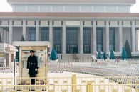 Man in Black Jacket Standing on White Concrete Building