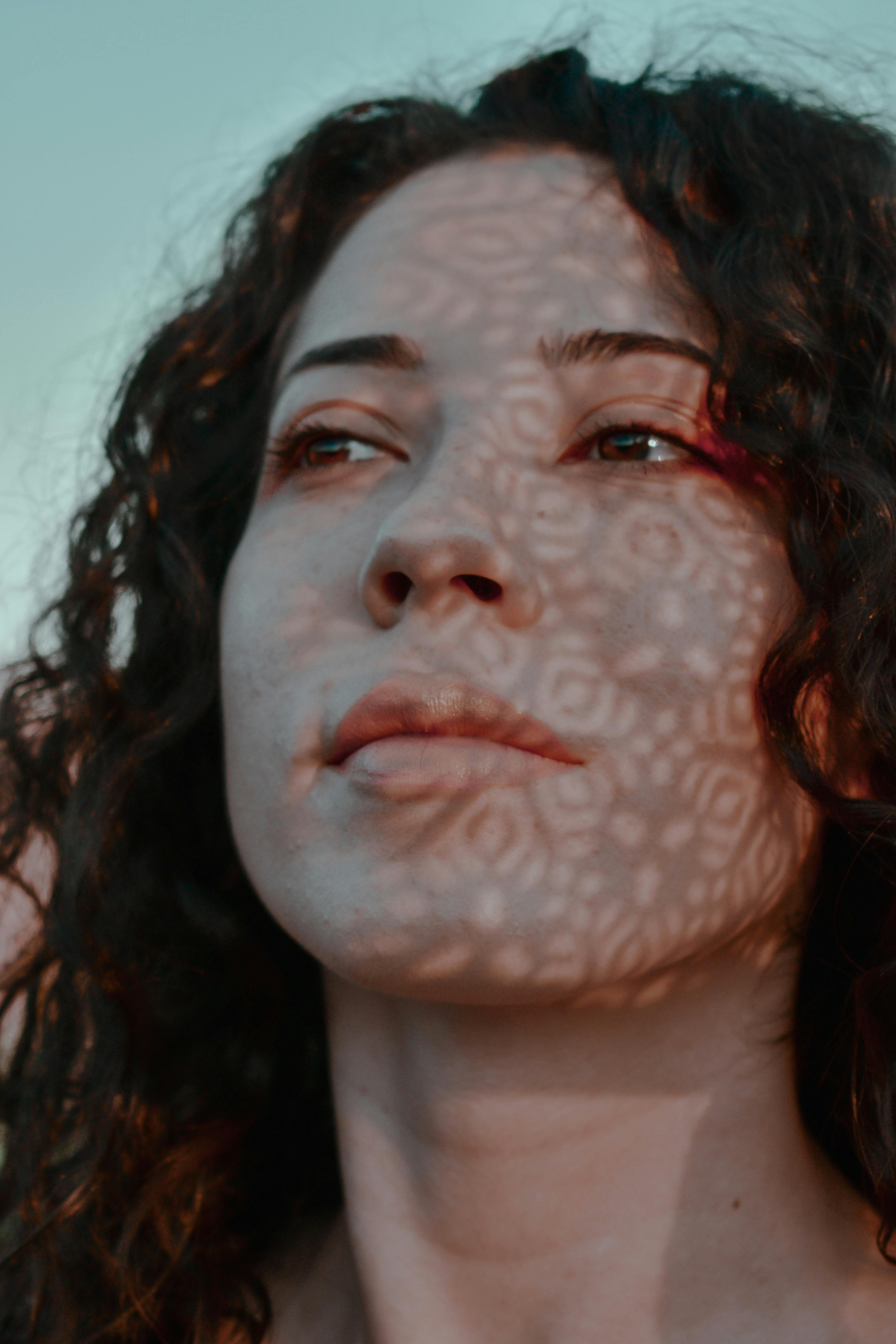 Pensive woman with curly hair looking away \u00b7 Free Stock Photo