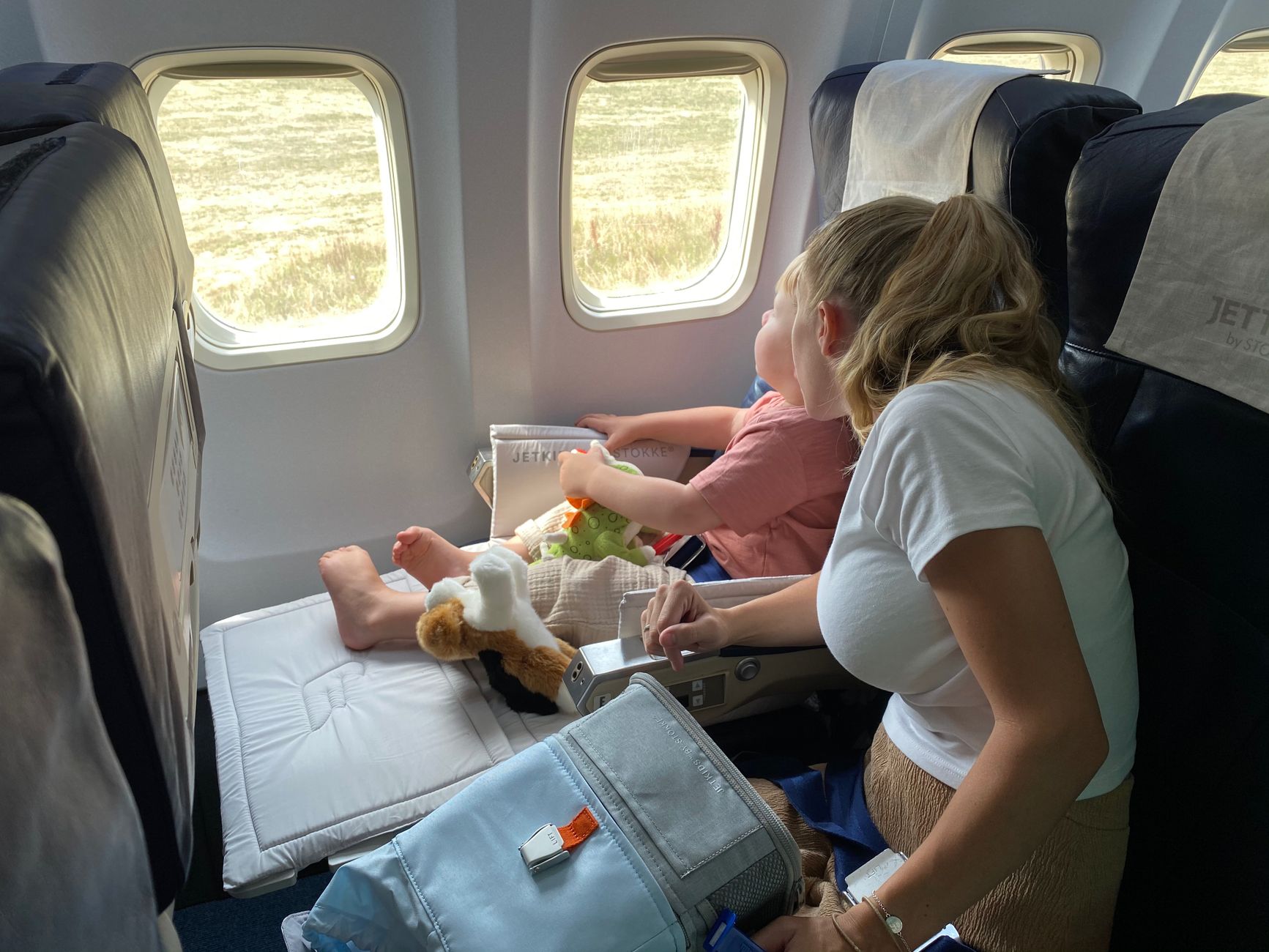Təyyarə pəncərəsindən baxan uşaq və valideynlər