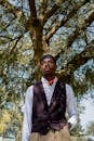 Elegant Man Standing in Shade Under Tree