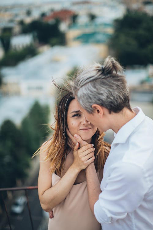 High angle of smiling romantic couple hugging tenderly while spending time together during date