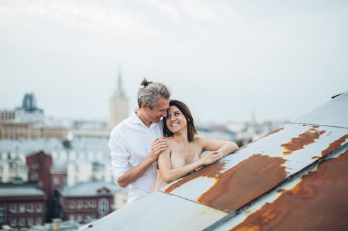 Smiling couple hugging on city roof
