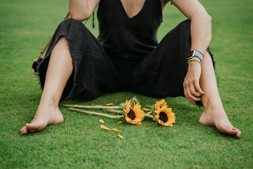Gratis Wanita Berbaju Hitam Tanpa Lengan Memegang Bunga Kuning Foto Stok