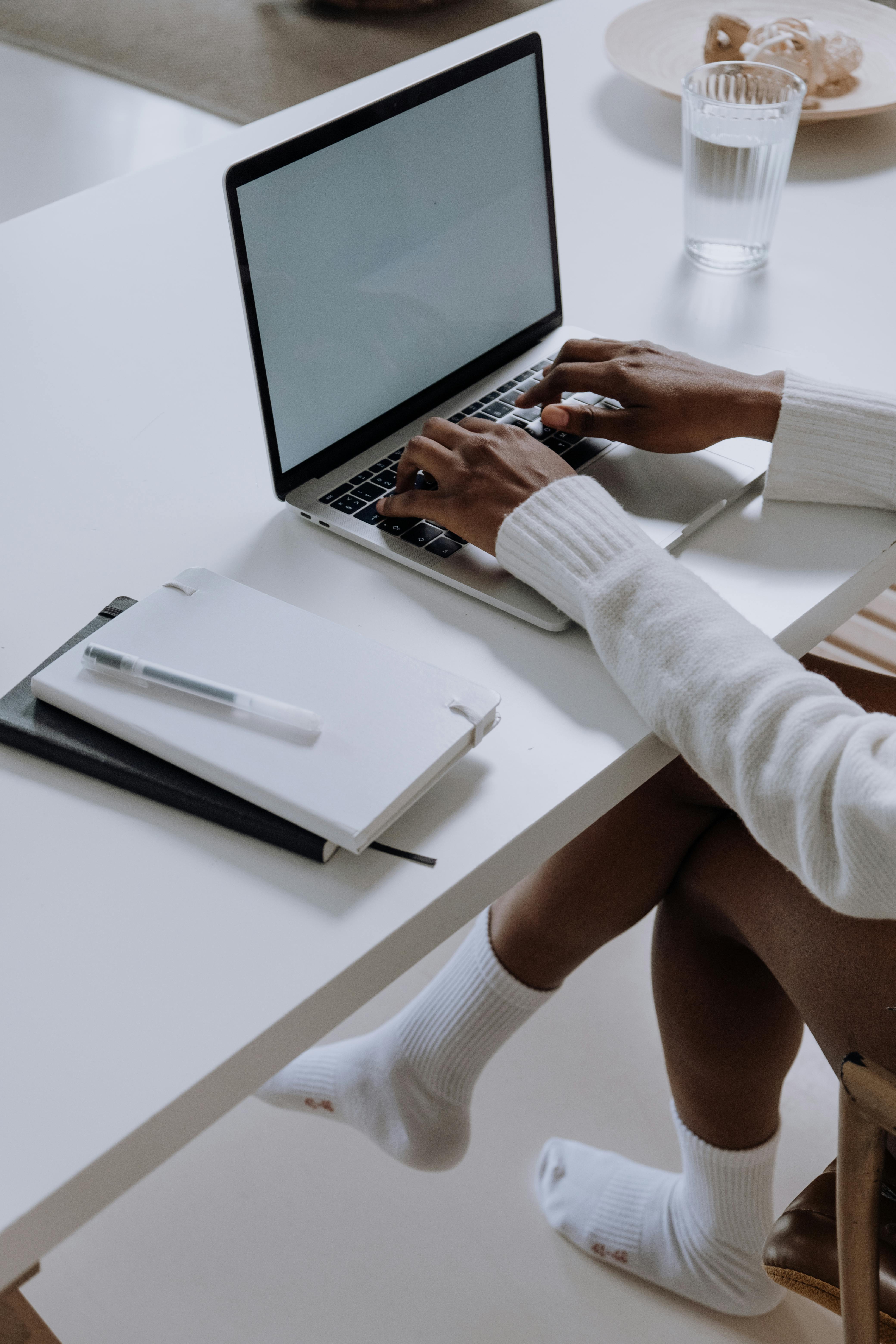 person in white long sleeve shirt using macbook pro