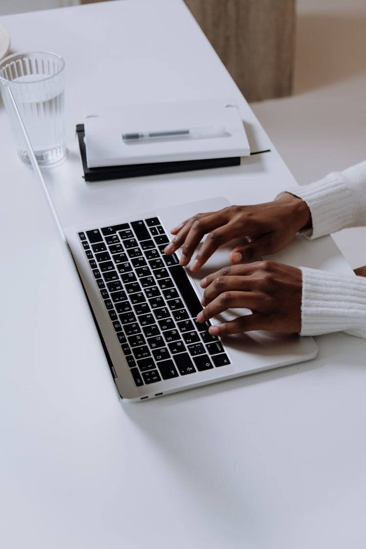 Person Using Macbook Pro On White Table