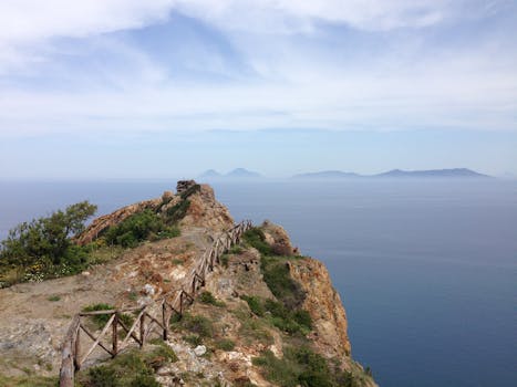 Breathtaking view of the Gioiosa Marea coastline in Sicily, featuring a rugged cliff and azure sea.