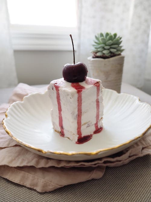 Free Sliced of White Cake with Cherry on Top Stock Photo