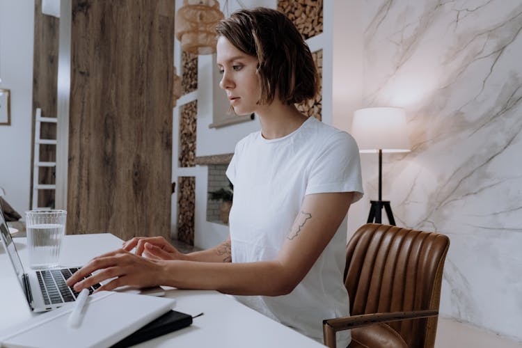 Woman In White Crew Neck T-shirt Using Macbook Air