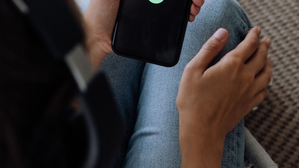 Person listening to music on a smartphone with headphones