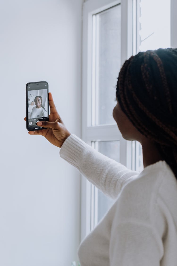 Woman In White Long Sleeve Shirt Holding Silver Iphone 6