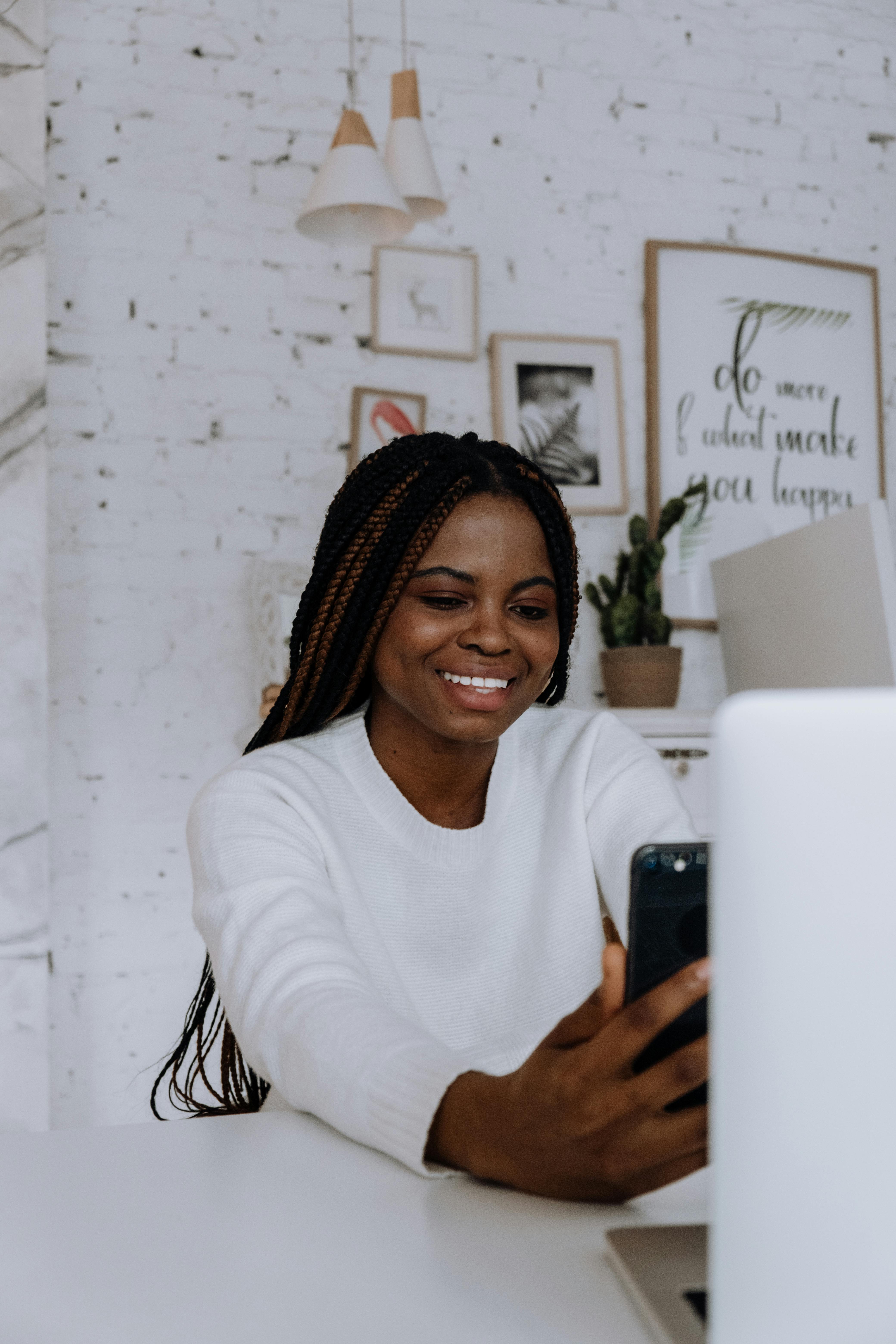 woman in white long sleeve shirt holding white smartphone