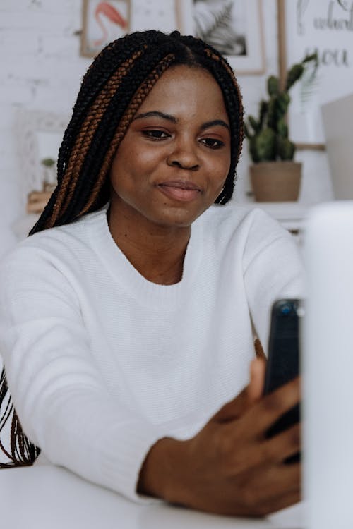 Woman in White Crew Neck Long Sleeve Shirt Wearing Brown and Black Woven Hat