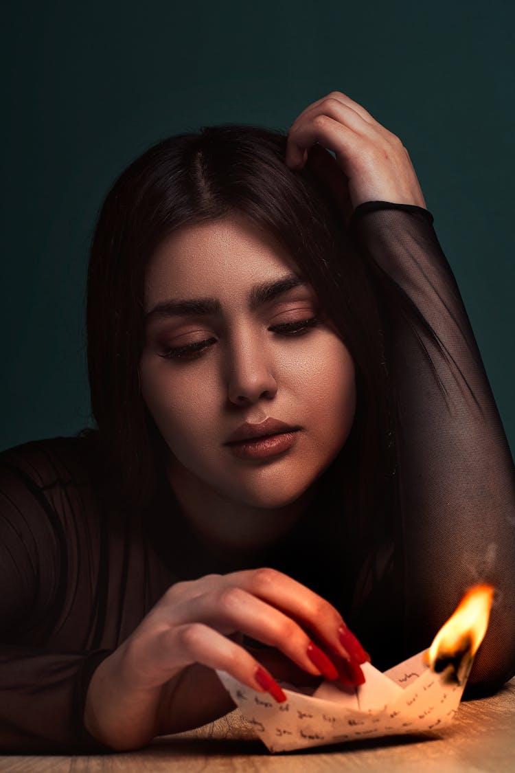 Portrait Of Woman Burning Paper Boat