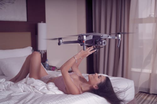 Woman with Drone in Bed