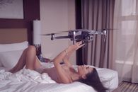 Woman Lying on Bed Holding Black and Silver Drone