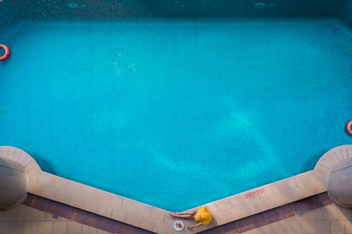 Aerial Photography of Woman Sitting by the Pool 