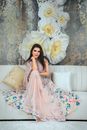Woman in Pink and White Floral Dress Sitting on White Couch