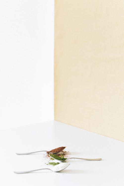 Free Spice Powder in the Stainless Spoon on the White Surface Stock Photo