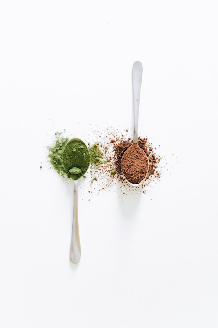 Brown Powder In The Spoon On The White Background