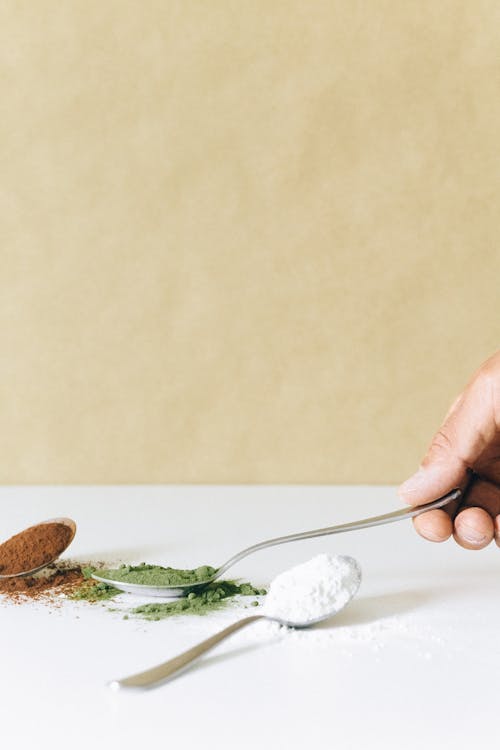 Person Holding Silver Spoon with Powder