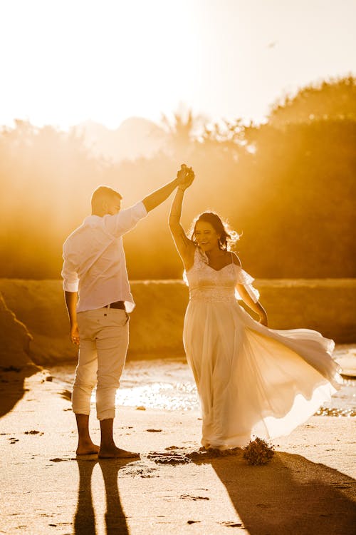 Cheerful Couple De Jeunes Mariés Dansant Sur La Côte De Sable Aux Beaux Jours