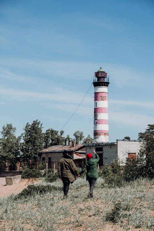 People Walking Towards a Lighthouse