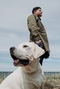 一个人和他的拉布拉多犬在海滩上享受阳光明媚的一天