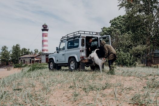 Explore Shepelyovsky Lighthouse with a dog and SUV on scenic Russian coast. Perfect for travel and adventure enthusiasts.