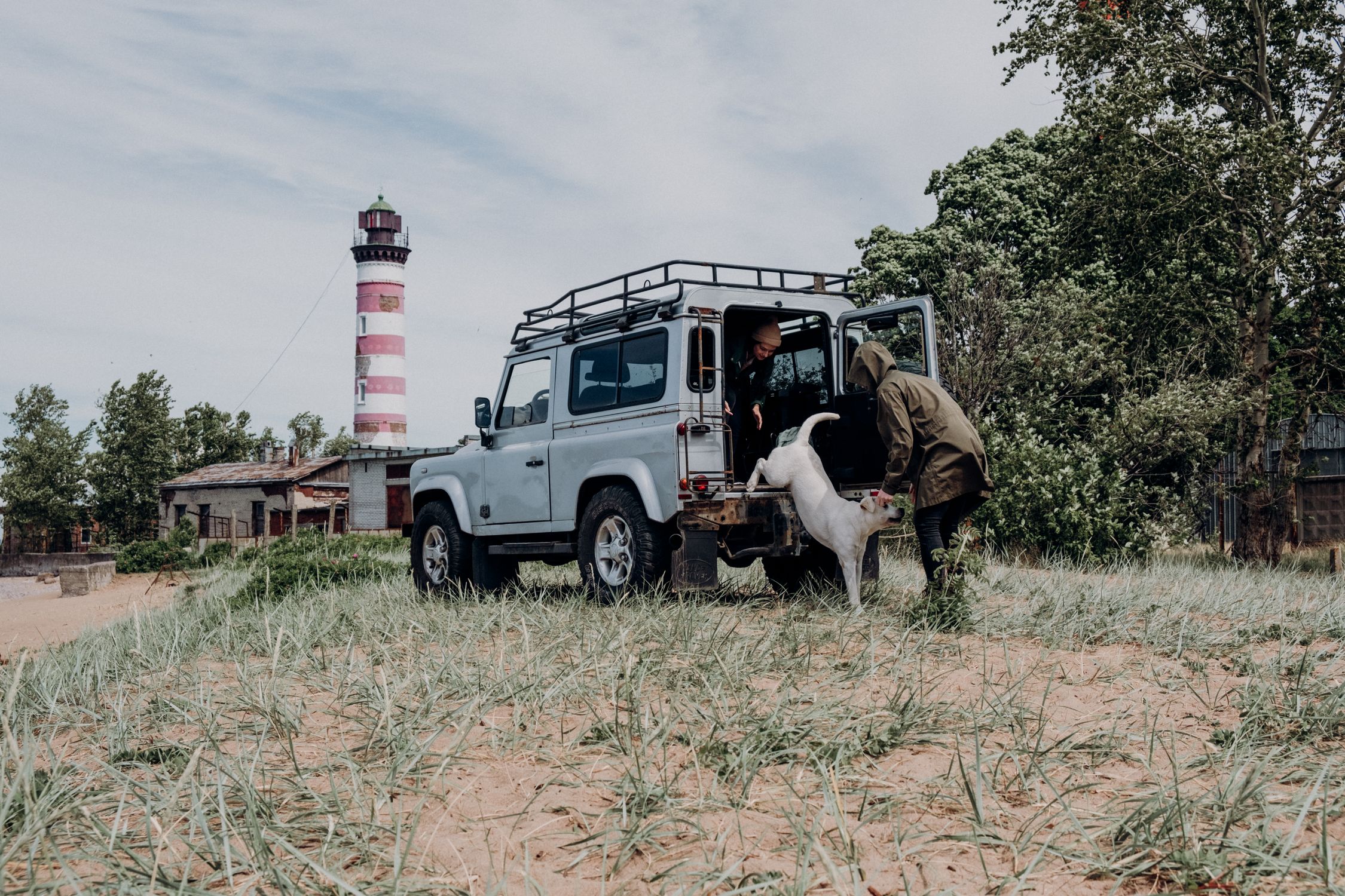 Explore Shepelyovsky Lighthouse with a dog and SUV on scenic Russian coast. Perfect for travel and adventure enthusiasts.