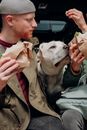 Man in Green Jacket Holding White Short Coated Dog