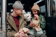 一对夫妇和他们的狗在户外探险中享用三明治