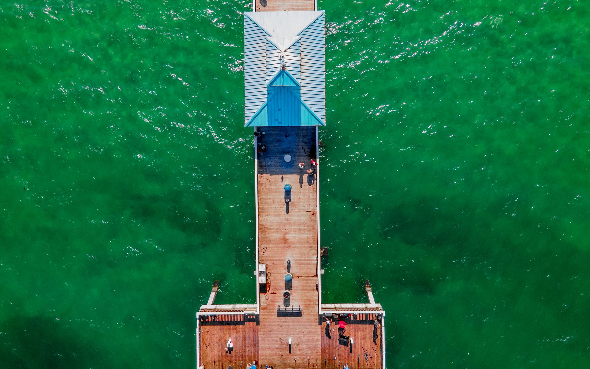 Stunning aerial view of Deerfield Beach Pier, showcasing vibrant green waters and a sunny day.