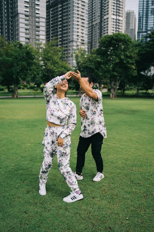 Homme En Chemise à Fleurs Blanche Et Noire Et Pantalon Noir Debout Sur Le Terrain De L'herbe Verte Pendant