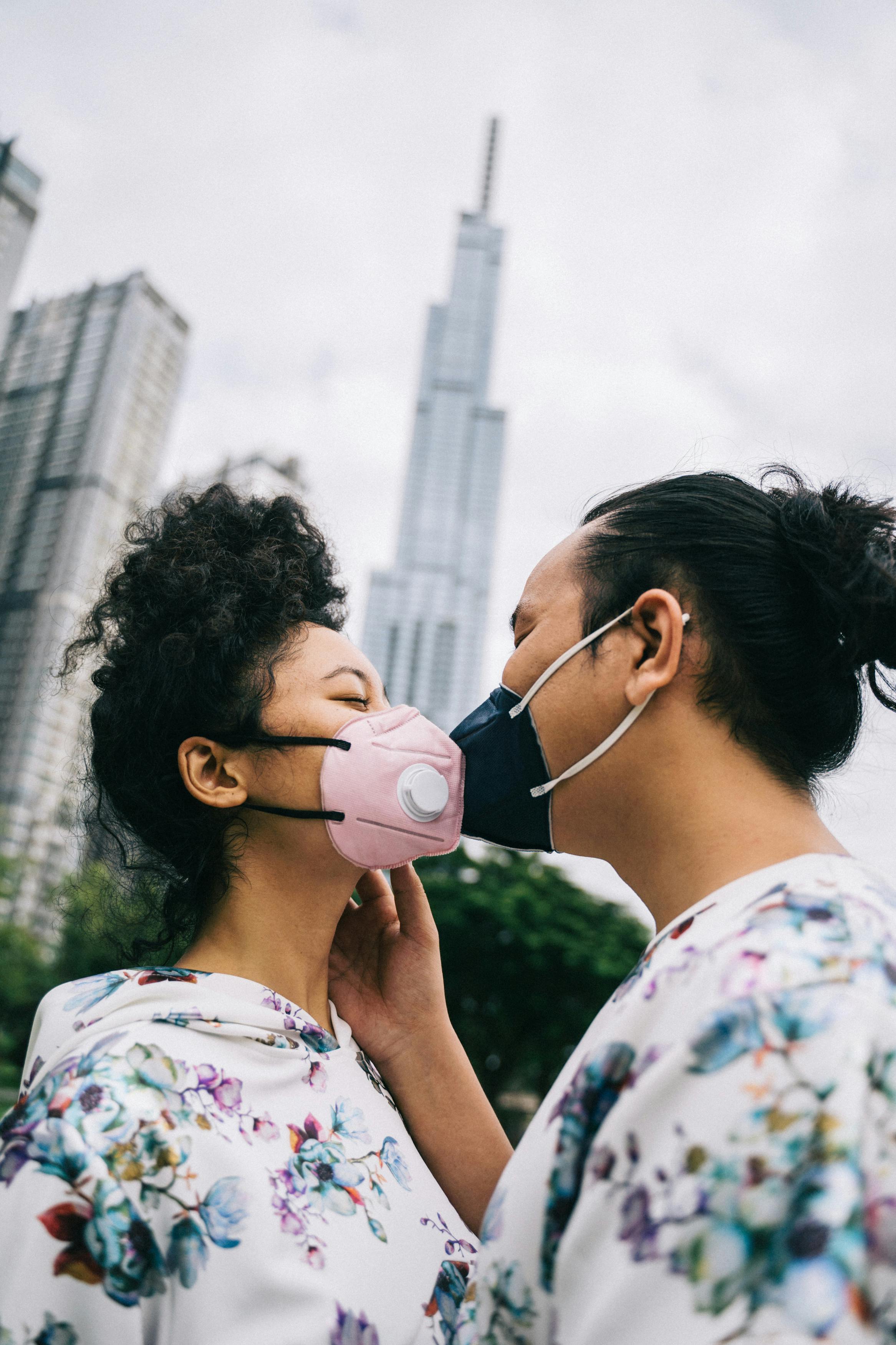 couple wearing face masks kissing