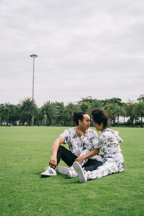 Homme Et Femme Assis Sur Le Terrain De L'herbe Verte