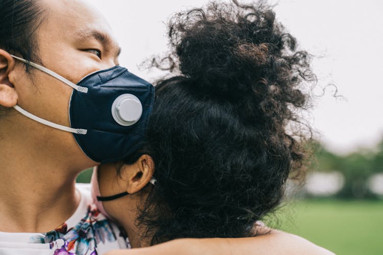 Couple With Face Masks Hugging