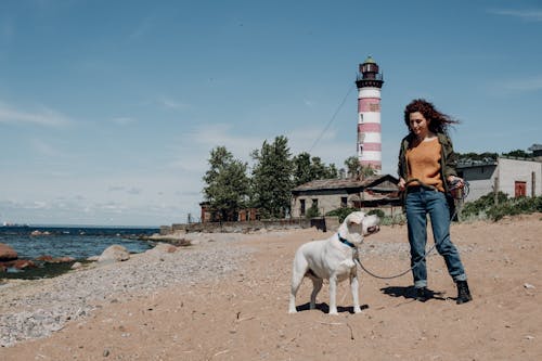 A Woman Posing with her Dog on the Beach