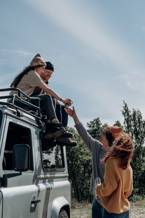 Free Group of friends enjoying a summer road trip with an SUV, relaxing outdoors and having fun. Stock Photo