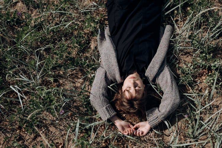 Top View Of A Woman Lying On Grass 